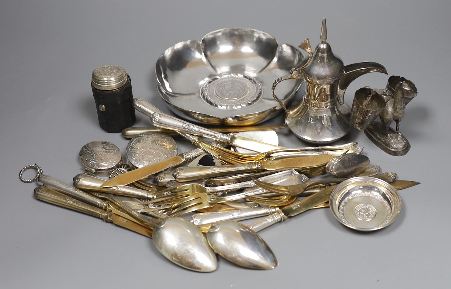 A Peruvian sterling dish with inset coin, an Egyptian white metal pill box, other 925 and white metal items including flatware, ring and sterling travelling beakers.